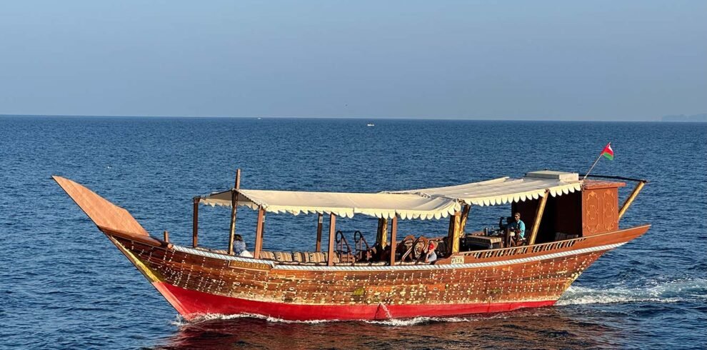 Un dhow tradizionale in legno naviga lungo le spettacolari coste del Sultanato dell'Oman