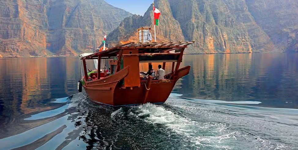 Tradizionale dhow in legno durante una crociera di mezza giornata nel fiordo di Khor Sham a Khasab, nella penisola del Musandam, Oman.