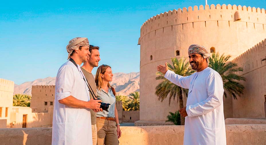Een Omaanse gids geeft uitleg voor een historisch fort in Oman